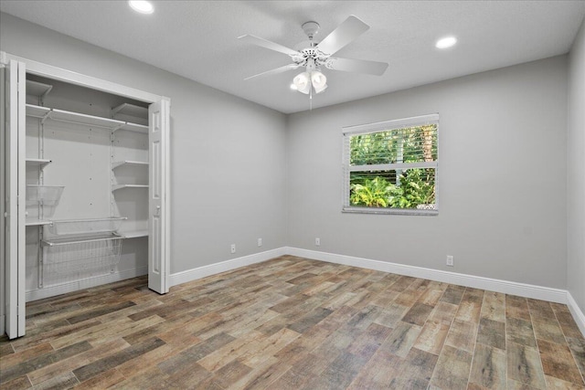 unfurnished bedroom featuring a closet, hardwood / wood-style flooring, and ceiling fan