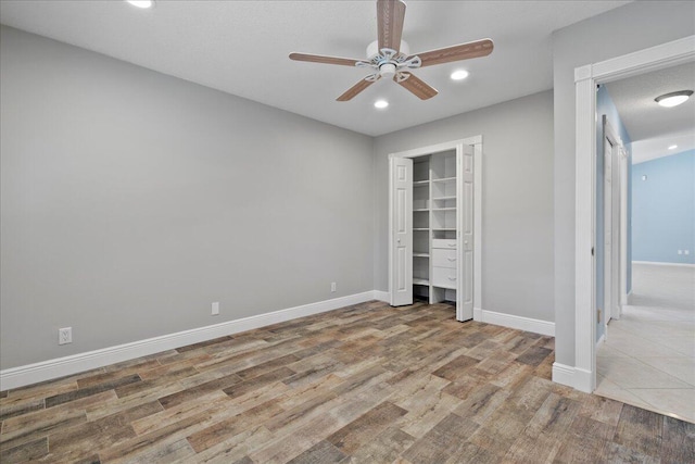 unfurnished bedroom with light wood-type flooring, a closet, and ceiling fan