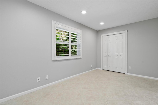 unfurnished bedroom featuring light tile patterned floors and a closet