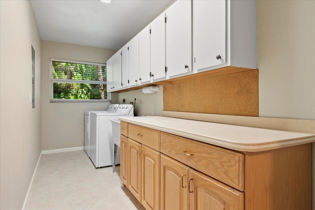 laundry area with cabinets, independent washer and dryer, and light tile patterned floors