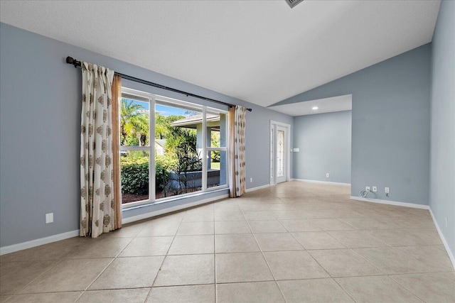 tiled empty room with lofted ceiling