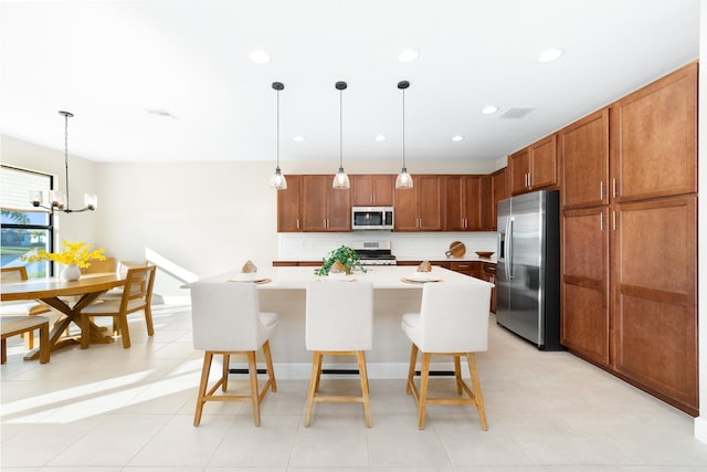 kitchen with a kitchen bar, backsplash, stainless steel appliances, a center island, and hanging light fixtures