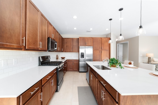 kitchen with sink, a center island with sink, decorative light fixtures, and appliances with stainless steel finishes