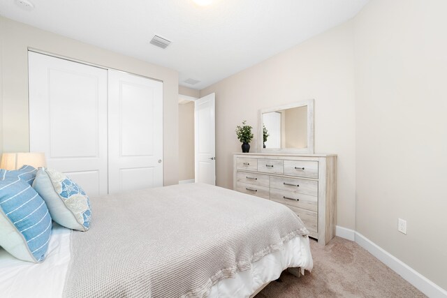 bedroom featuring a closet and light colored carpet