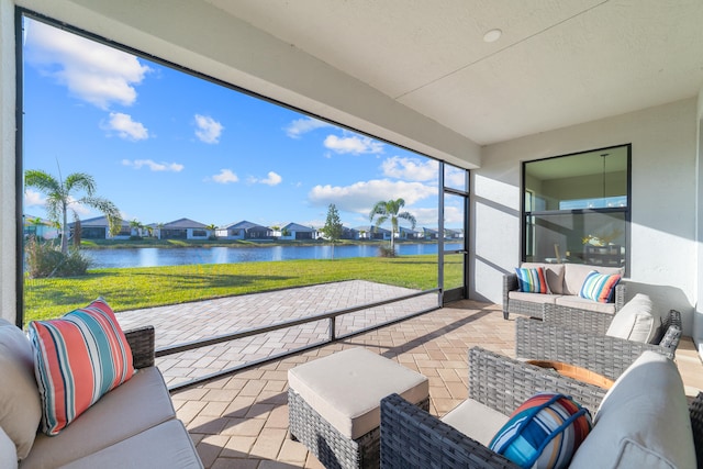 sunroom featuring a water view