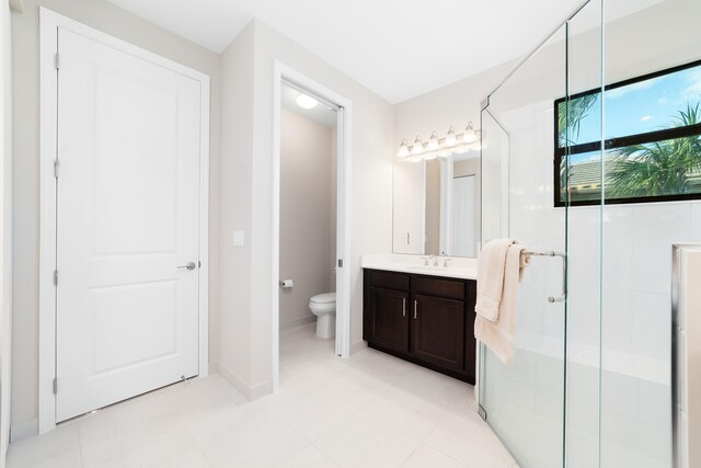 bathroom featuring a shower with door, vanity, and toilet