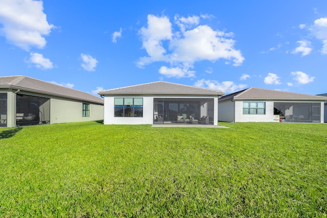 rear view of property featuring a lawn and a sunroom