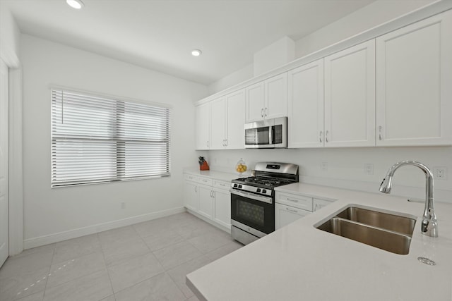 kitchen with white cabinetry, sink, light tile patterned flooring, and appliances with stainless steel finishes