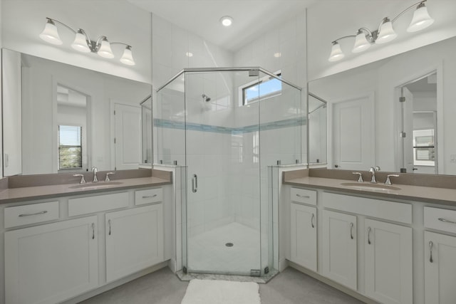 bathroom featuring a shower with door and vanity