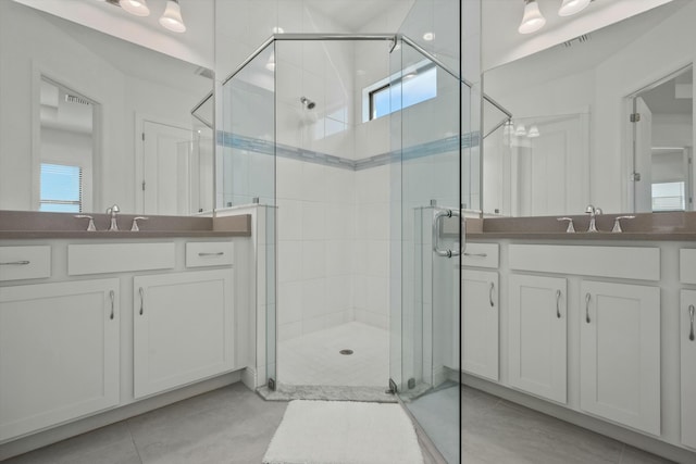 bathroom featuring a wealth of natural light, vanity, and a shower with shower door