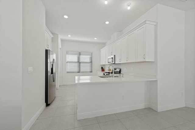 kitchen featuring kitchen peninsula, white cabinetry, light tile patterned floors, and appliances with stainless steel finishes