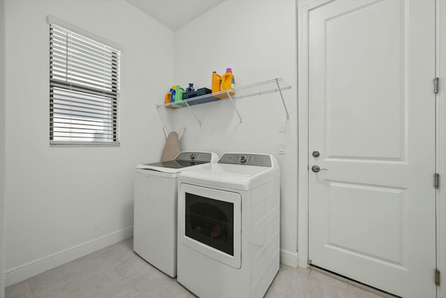 clothes washing area featuring light tile patterned flooring and separate washer and dryer