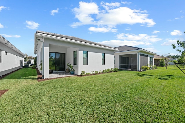 rear view of property with a sunroom and a yard