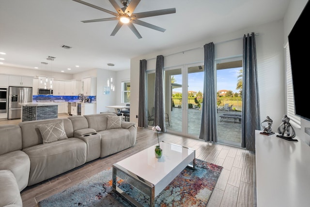 living room featuring french doors, light hardwood / wood-style floors, and ceiling fan