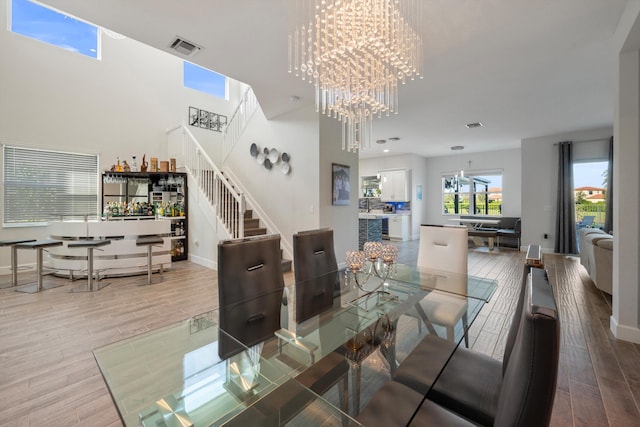 dining room featuring a chandelier, a high ceiling, and hardwood / wood-style flooring