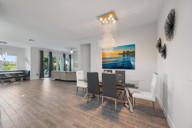 dining room with wood-type flooring and an inviting chandelier