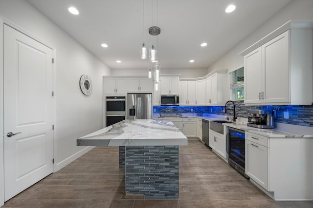 kitchen featuring sink, beverage cooler, a kitchen island, white cabinets, and appliances with stainless steel finishes