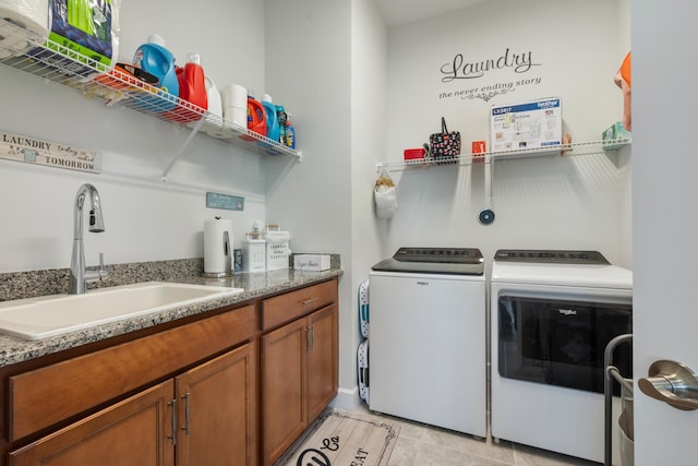 clothes washing area with light tile patterned flooring, sink, and washing machine and clothes dryer