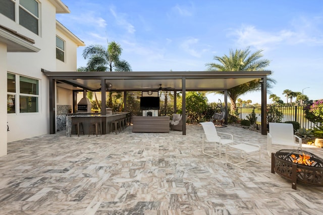 view of patio featuring exterior bar, outdoor lounge area, and ceiling fan