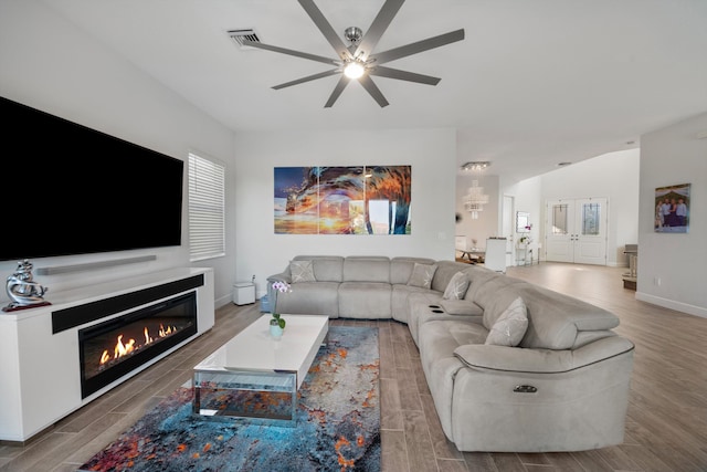 living room with wood-type flooring, ceiling fan, and lofted ceiling