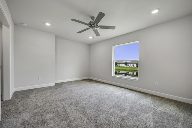 carpeted spare room with ceiling fan