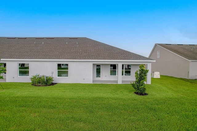 rear view of property featuring a yard