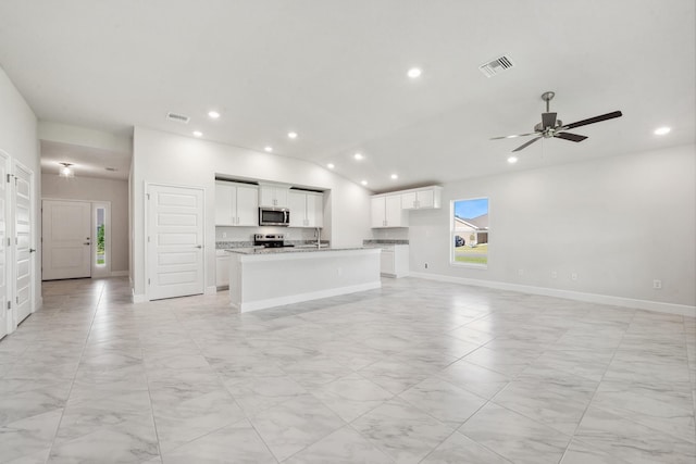 unfurnished living room with vaulted ceiling, ceiling fan, and sink