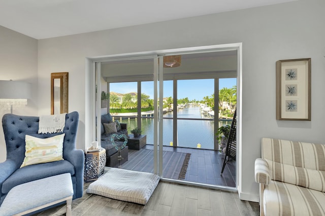 living room featuring hardwood / wood-style flooring, a water view, and a wealth of natural light