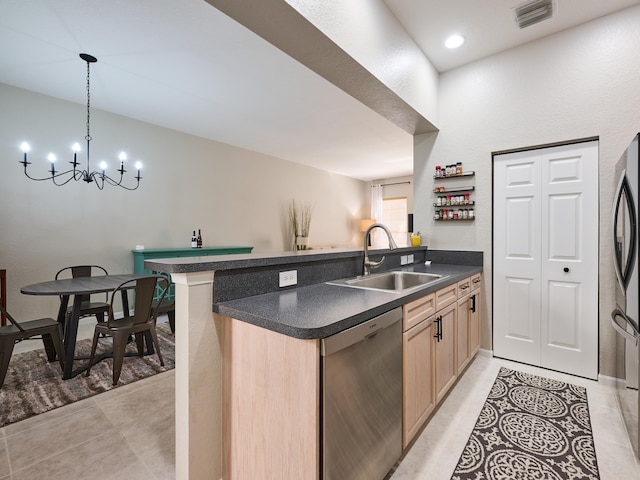 kitchen featuring kitchen peninsula, light brown cabinetry, stainless steel dishwasher, sink, and a notable chandelier