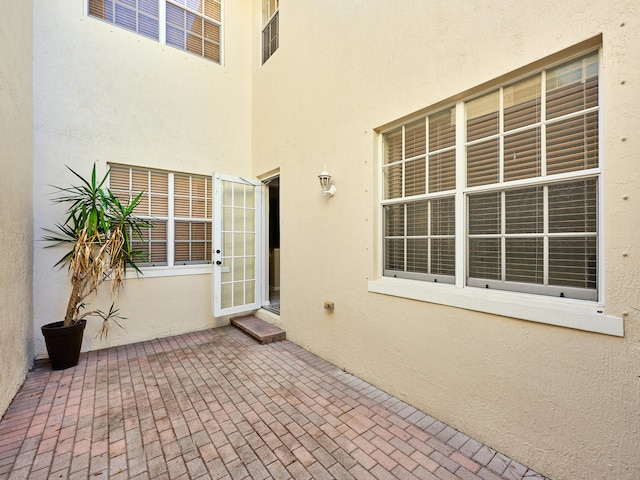 view of exterior entry with a patio