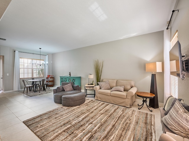 tiled living room featuring an inviting chandelier