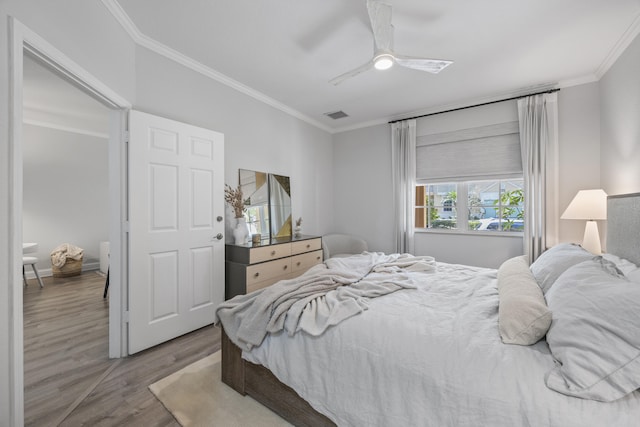 bedroom featuring hardwood / wood-style flooring, ceiling fan, and ornamental molding