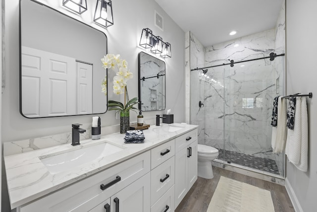 bathroom featuring hardwood / wood-style floors, vanity, toilet, and an enclosed shower