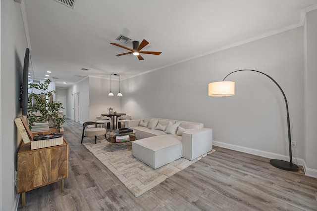 living room with hardwood / wood-style floors, ceiling fan, and ornamental molding