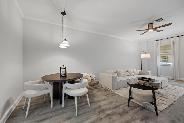 dining space featuring hardwood / wood-style floors, ceiling fan, and crown molding