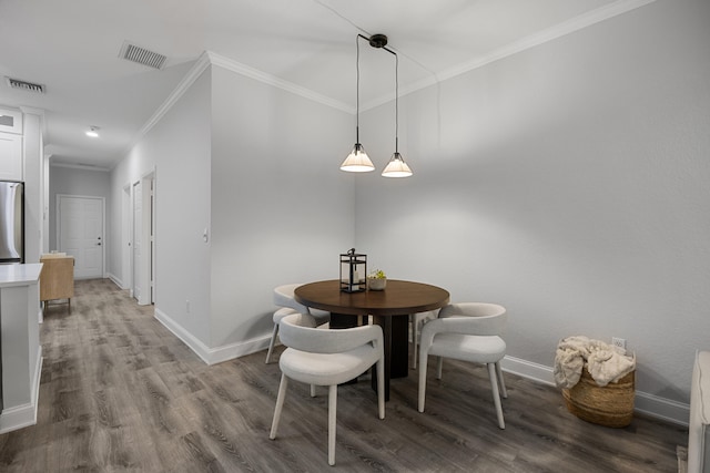 dining room with hardwood / wood-style flooring and crown molding