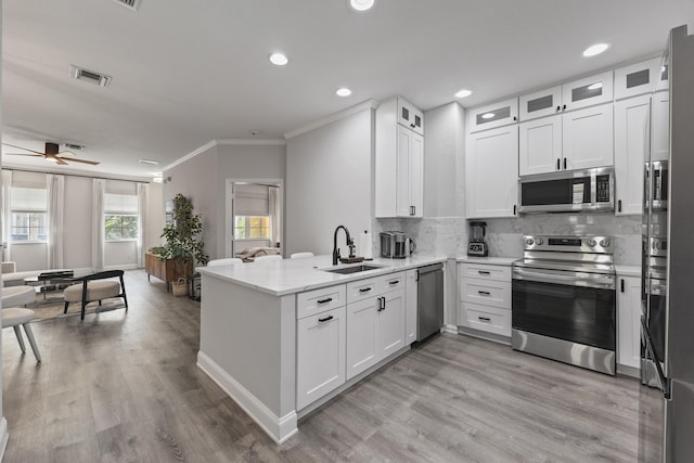 kitchen featuring kitchen peninsula, white cabinetry, sink, and stainless steel appliances