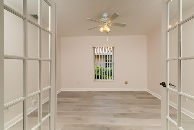 empty room with ceiling fan and light wood-type flooring