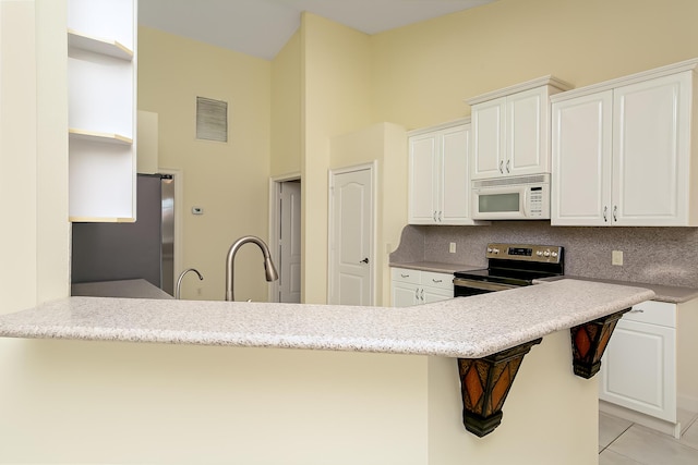 kitchen featuring stainless steel appliances, white cabinetry, a breakfast bar area, and kitchen peninsula