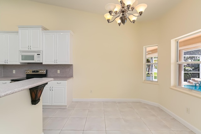 kitchen featuring tasteful backsplash, stainless steel range with electric cooktop, white cabinets, and light tile patterned flooring