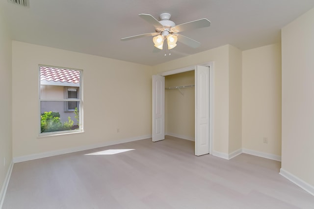 unfurnished bedroom with ceiling fan, a closet, and light hardwood / wood-style flooring