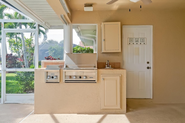 exterior space with white cabinetry, sink, and ceiling fan