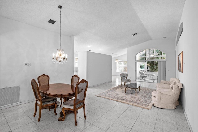 tiled dining space with a textured ceiling, an inviting chandelier, and vaulted ceiling