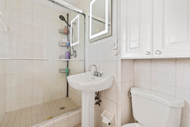 bathroom with an enclosed shower, toilet, and tile walls