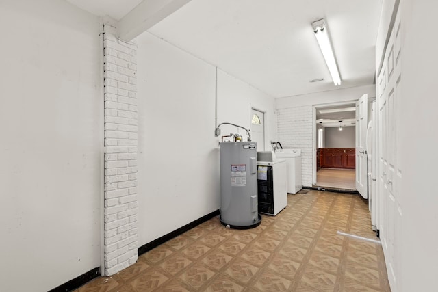 laundry room with light parquet floors, washing machine and clothes dryer, brick wall, and water heater