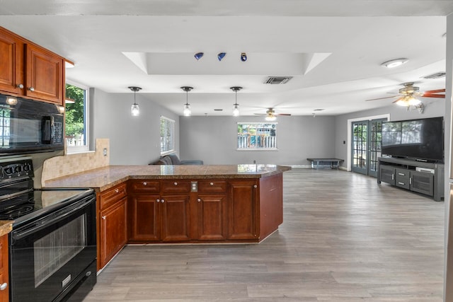 kitchen featuring kitchen peninsula, a healthy amount of sunlight, and black appliances