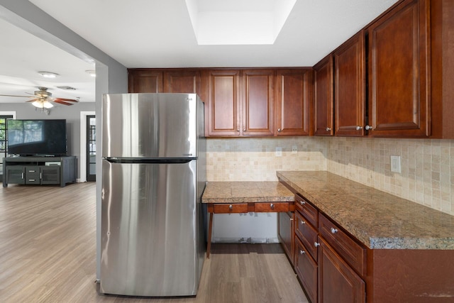 kitchen with stainless steel fridge, light wood-type flooring, ceiling fan, and backsplash