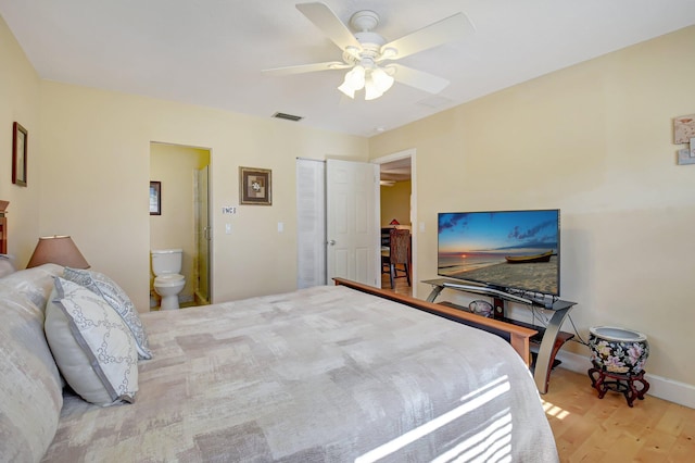 bedroom featuring a closet, connected bathroom, ceiling fan, and light hardwood / wood-style flooring