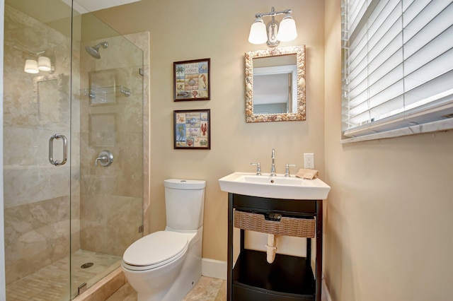 bathroom with tile patterned floors, toilet, a shower with shower door, and sink