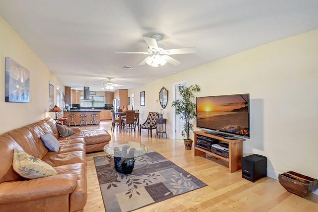 living room with ceiling fan and light hardwood / wood-style floors